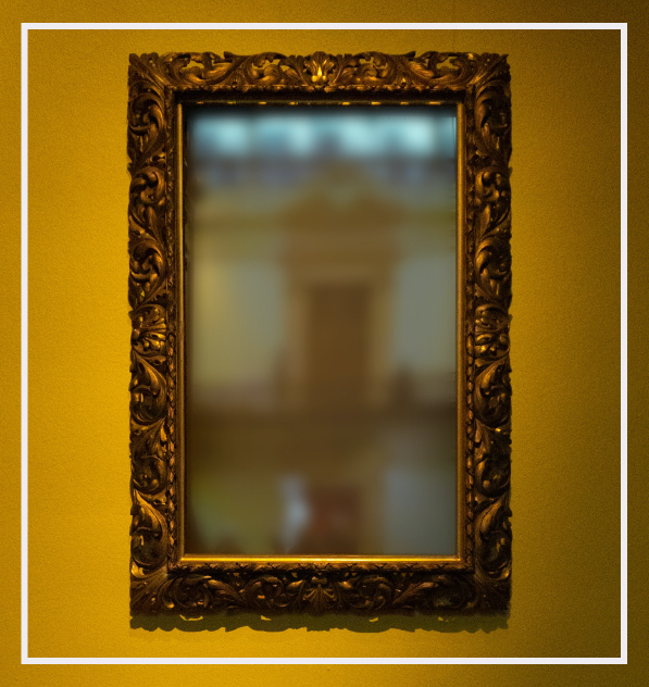 cloudy mirror against a yellow wall