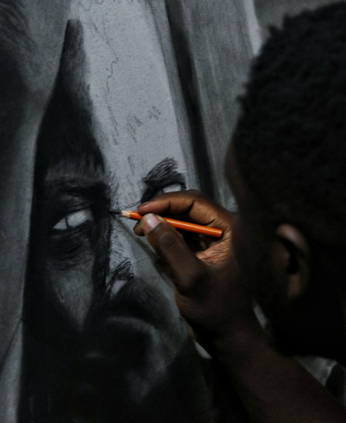 artist drawing a man's portrait with charcoal