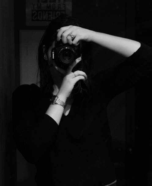 artist holding a camera to obscure their face