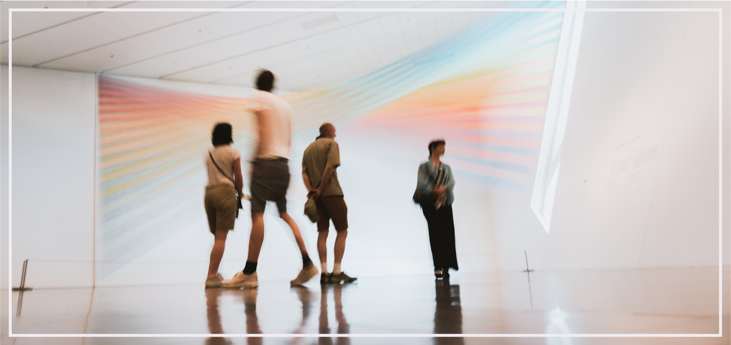 people viewing a rainbow prism light sculpture