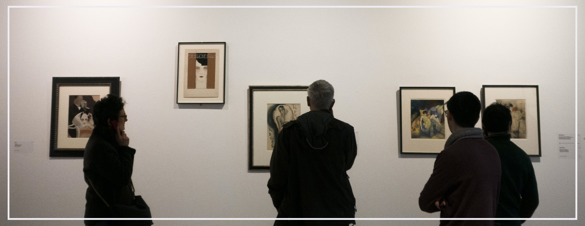 people looking at graphic images on exhibition wall